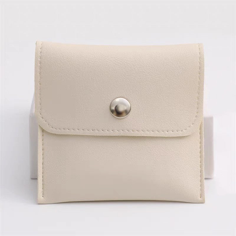 Soft cream-colored jewelry pouch with snap closure, ideal for storing the Wave Pearl Cuff Bracelet or other accessories.
