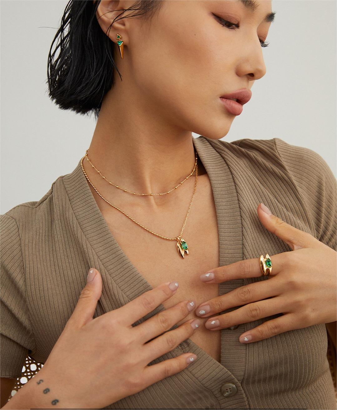 Model wearing Handmade Green Zircon Necklace in gold vermeil with matching ring and earrings, highlighting the elegant green gemstone.