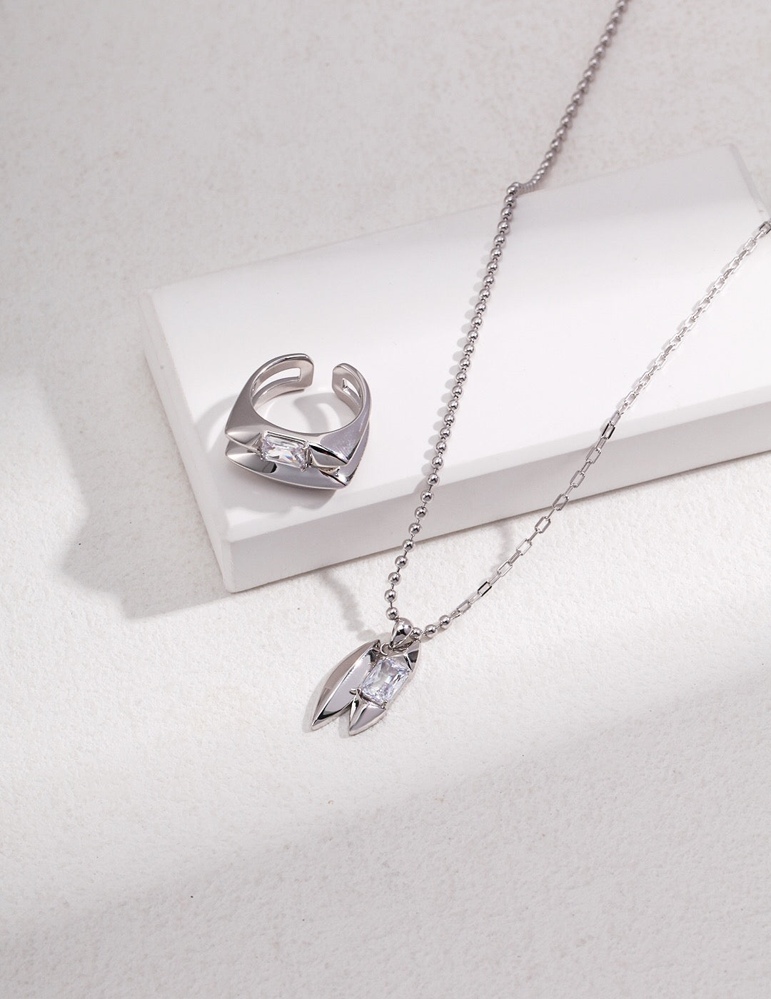 Silver version of the Handmade Green Zircon Necklace and matching ring, featuring a clear zircon pendant on a sterling silver chain.