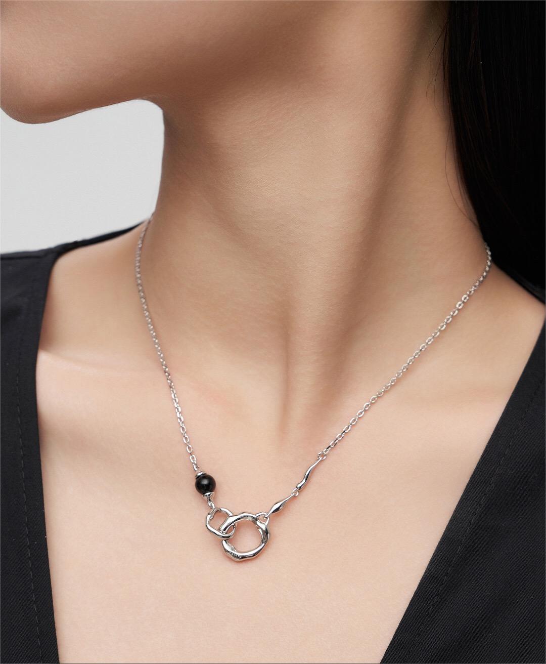 Silver Roundness Hollow Round Black Onyx Necklace worn on model, featuring black onyx bead and sculptural circular pendant.