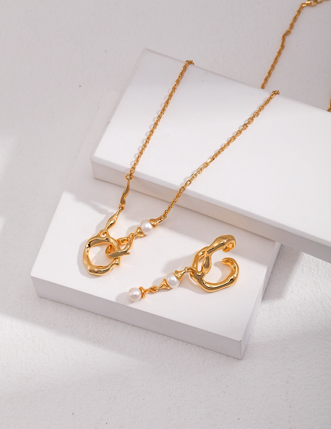 Gold Roundness Hollow Round Pearl Necklace and matching drop earrings with pearl accents, displayed on white background.