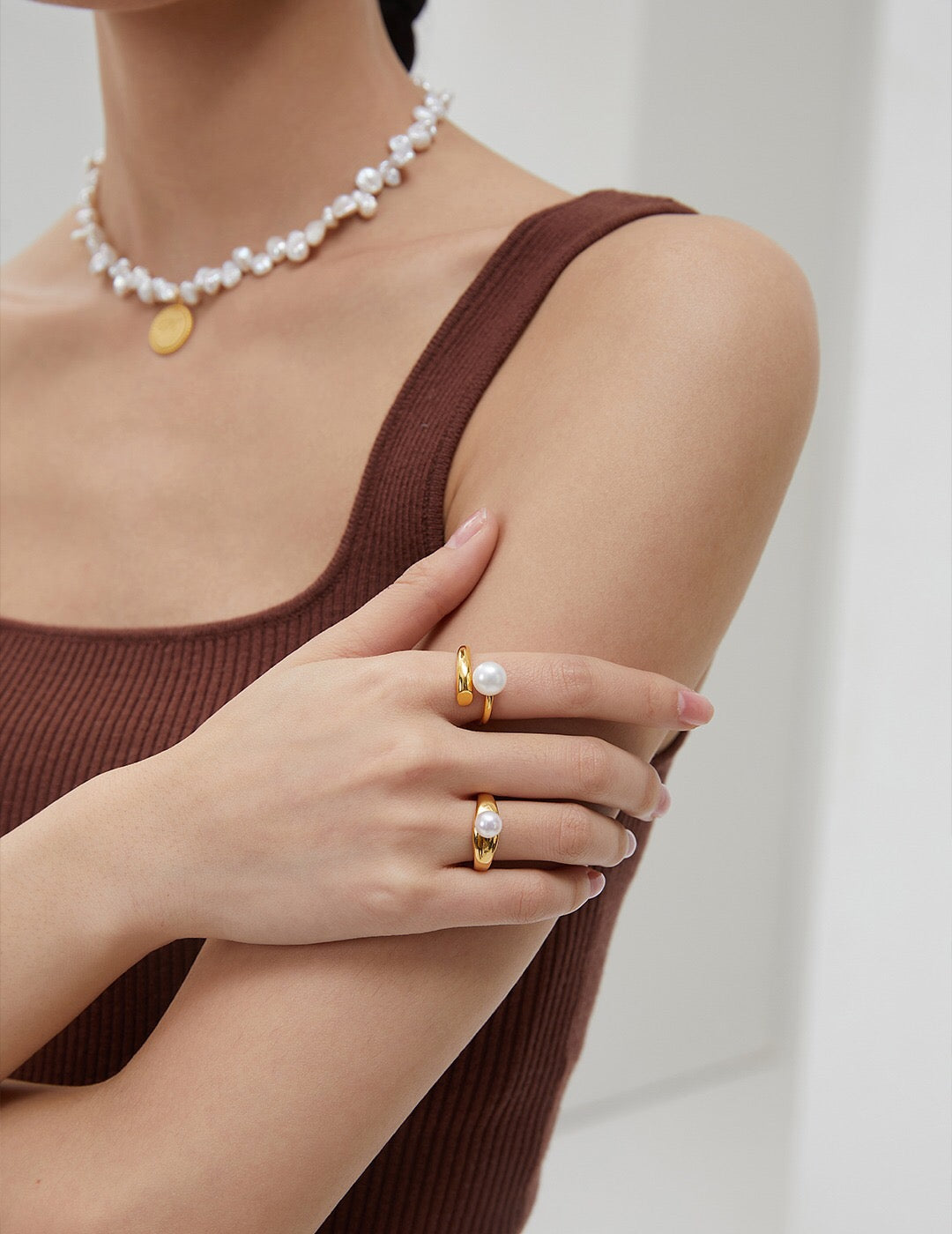 Close-up of hands adorned with Gold Vermeil Pearl Rings. Freshwater pearls and 18k gold-plated finish highlight luxury and style.