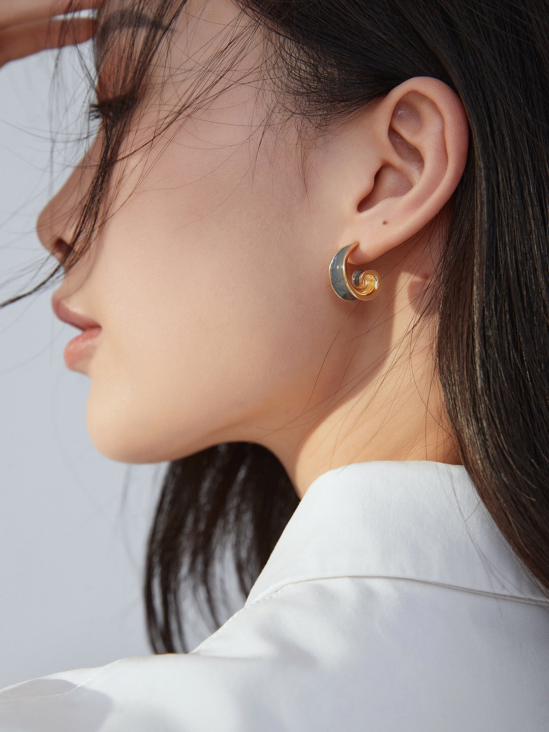 Model wearing Helix Gray Drip Glaze Earrings, highlighting the elegant swirl hoop with tarnish-resistant gold vermeil craftsmanship.