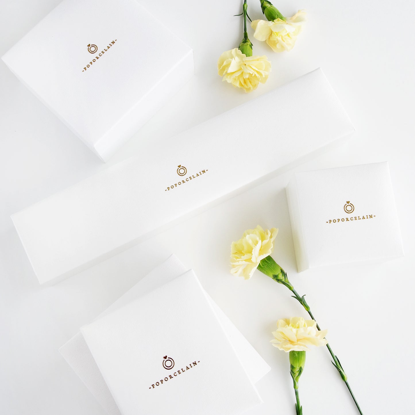 Branded packaging for Porcelain Moonlight Rose Earrings by Poporcelain, featuring elegant white boxes and floral accents for gifting.