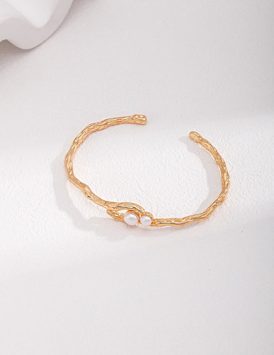 Double-Pearl Cuff Bracelet - Handmade Pearl Cuff with freshwater pearls and 18k gold-plated twisted band, displayed on white background.