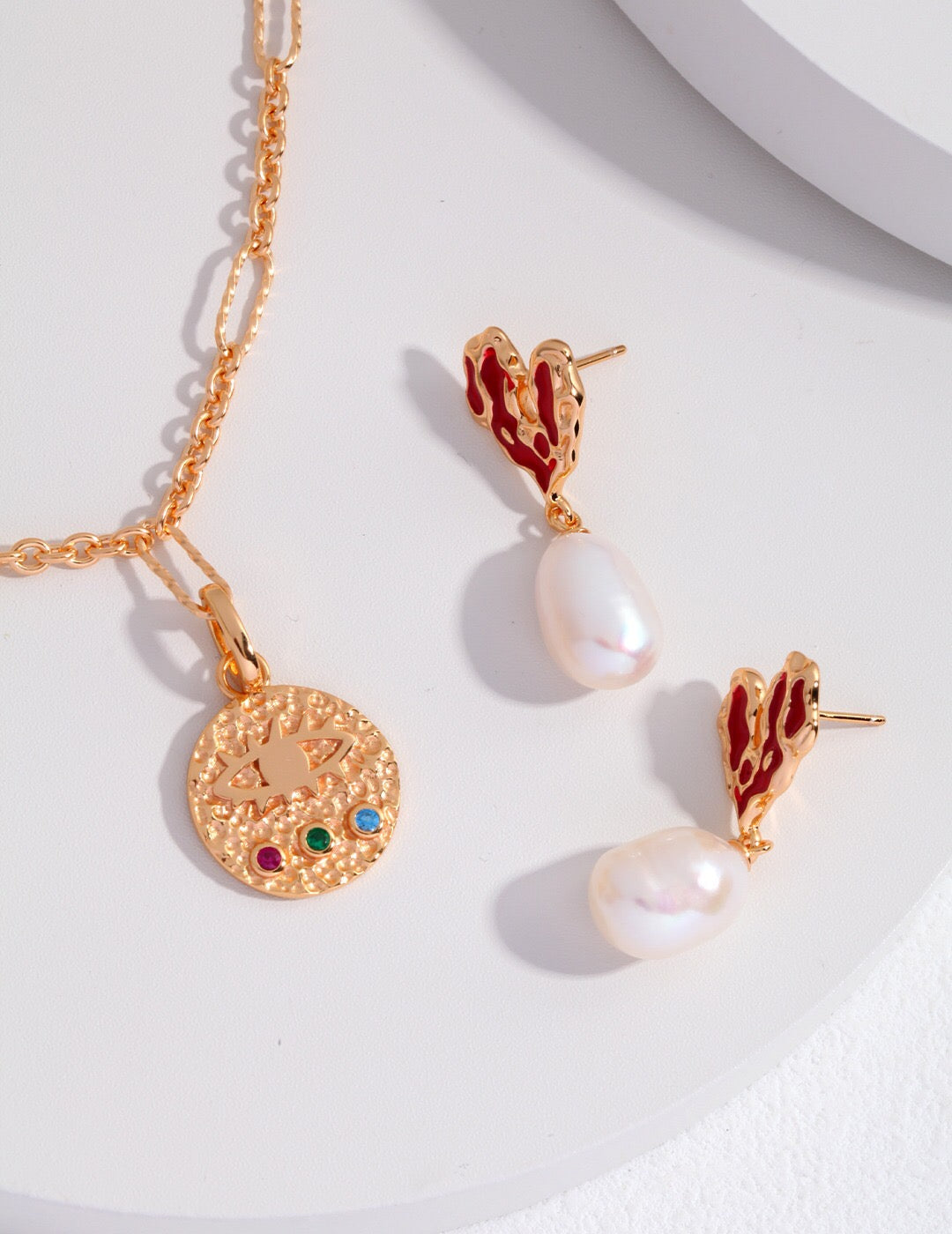 Gold Heart Pearl Earrings paired with a gold medallion necklace, featuring freshwater pearls and red enamel hearts.
