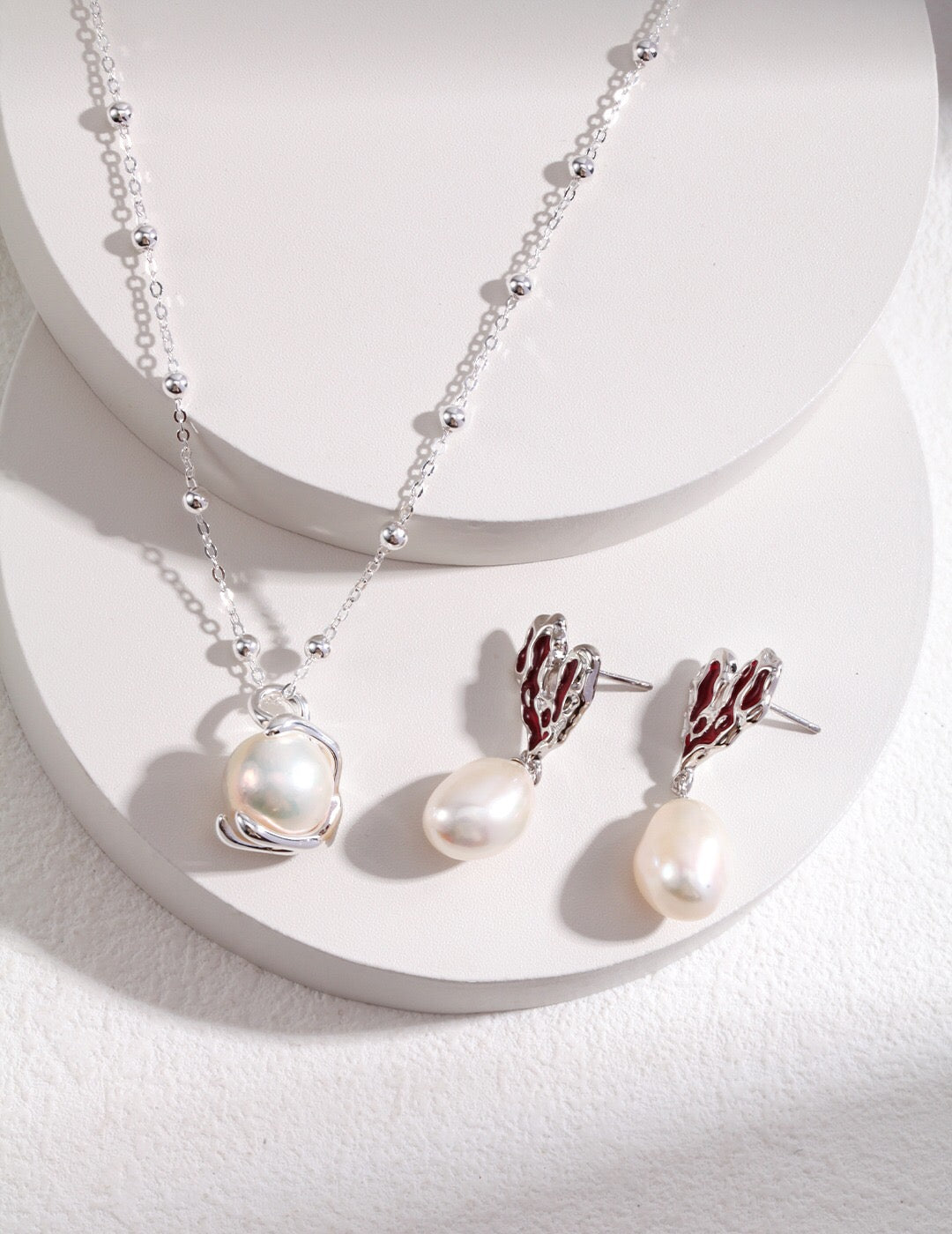 Silver Heart Pearl Earrings shown with a matching silver pearl necklace, featuring red enamel hearts and freshwater pearls.