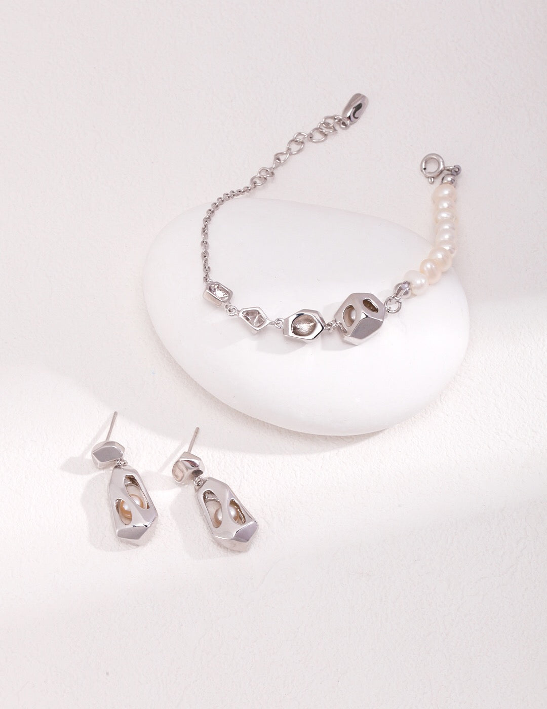 Silver-toned openwork pearl earrings and matching bracelet with freshwater pearls, hypoallergenic and handcrafted for modern elegance.