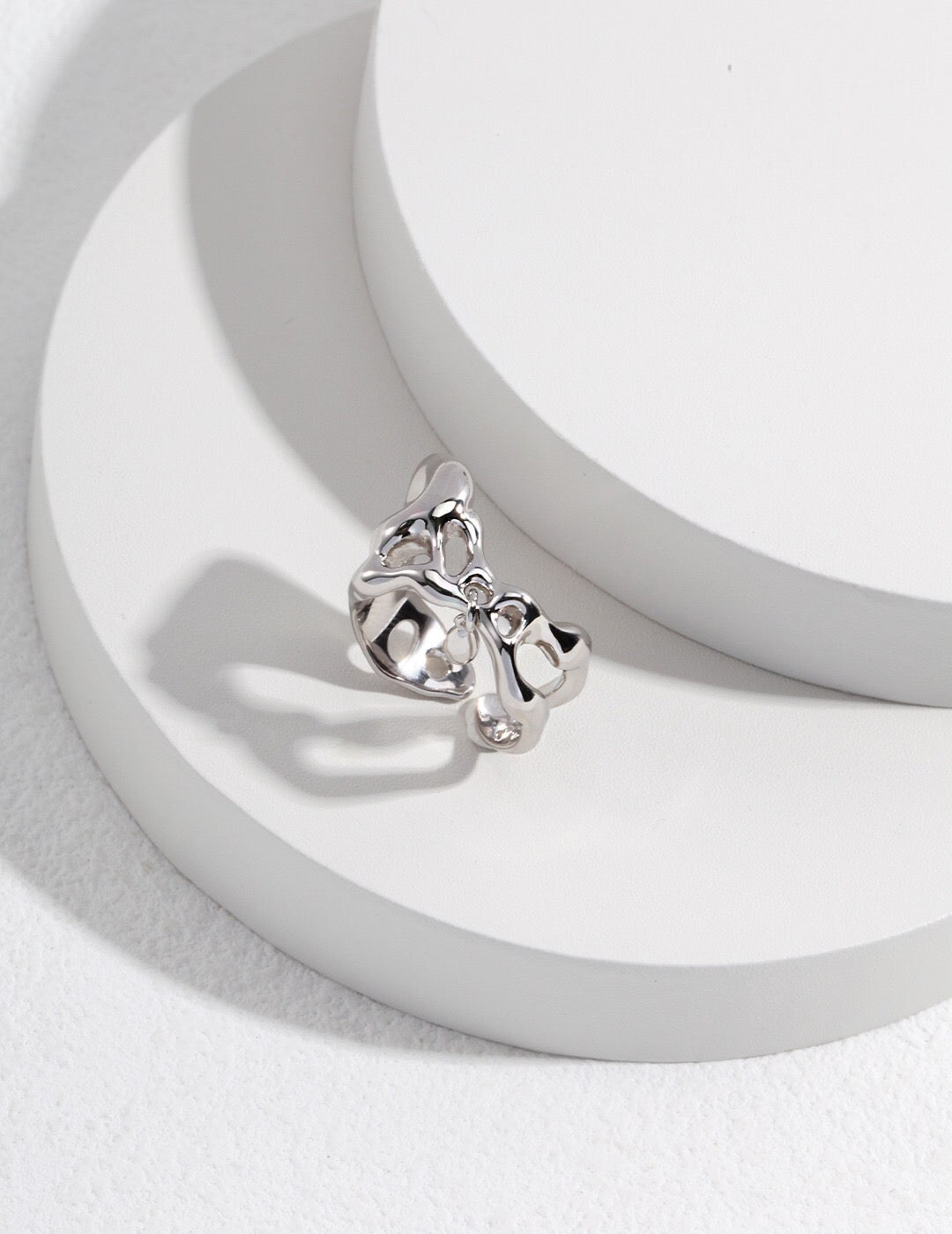 Sterling silver version of the Minimalist Irregular Teardrop Pendant Ring with polished finish and teardrop charm, placed on a white display.