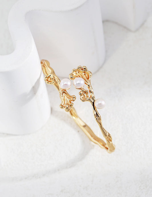 Wave Pearl Cuff Bracelet in 18k gold-plated sterling silver with natural pearls, adjustable and hypoallergenic, displayed on white decor.