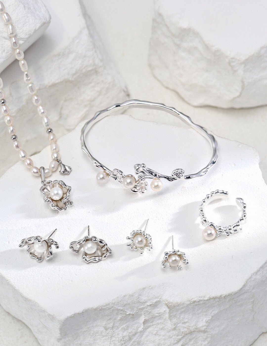 Silver Wave Pearl Cuff Bracelet with coordinating pearl earrings and necklace, hypoallergenic sterling silver jewelry set on white display.
