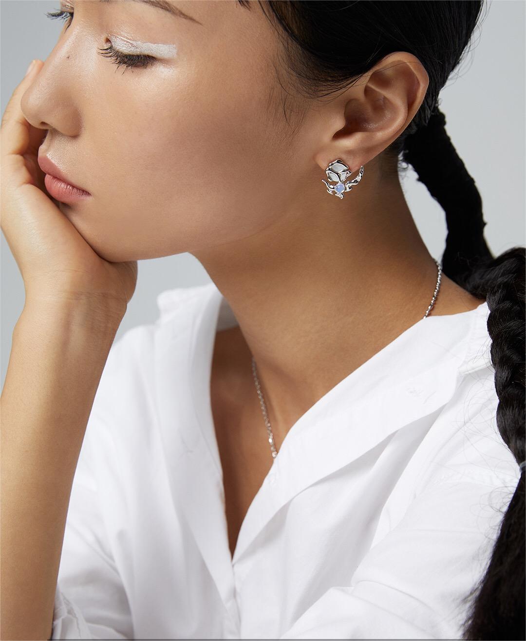 Close-up of model wearing one silver Crescent Moon Style Asymmetrical Opal Stud Earring, highlighting its unique crescent shape.