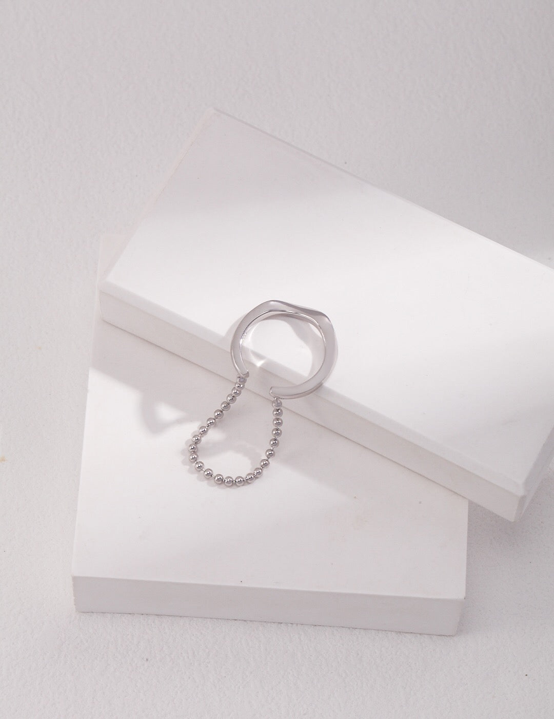 Handmade sterling silver irregular ring with beaded chain, adjustable design for a modern minimalist look. Tarnish-resistant and perfect for daily wear.