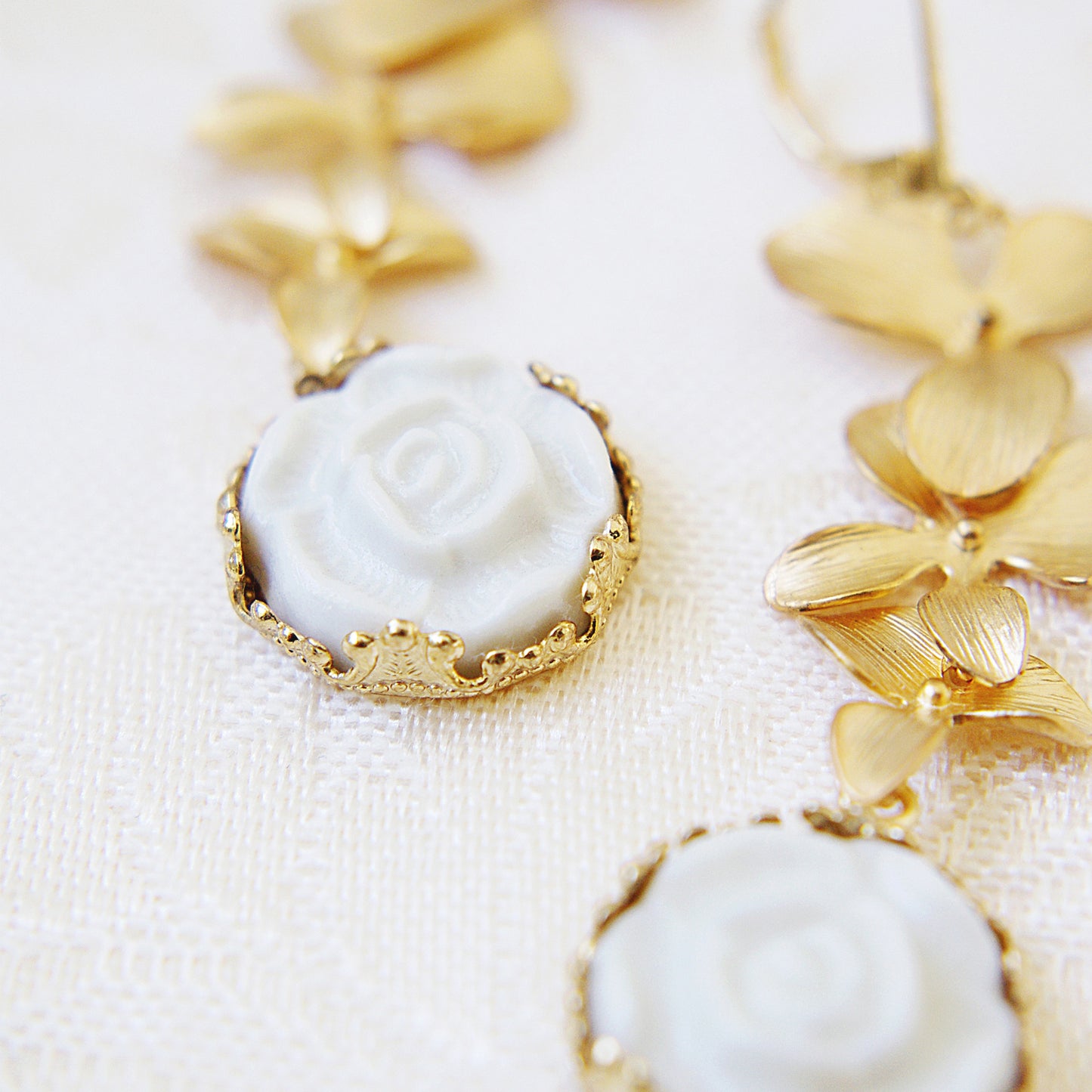 Close-up of Porcelain Moonlight Rose Earrings highlighting intricate gold leaf design and delicate white porcelain rose centerpiece.