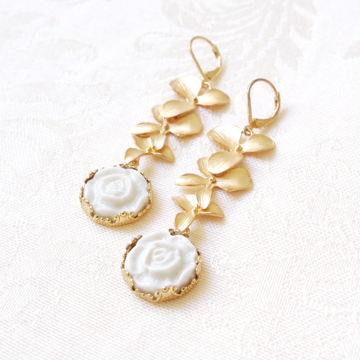 Porcelain Moonlight Rose and Triple Leaves Drop Earrings laid flat, showcasing handmade Danish craftsmanship and romantic floral design.