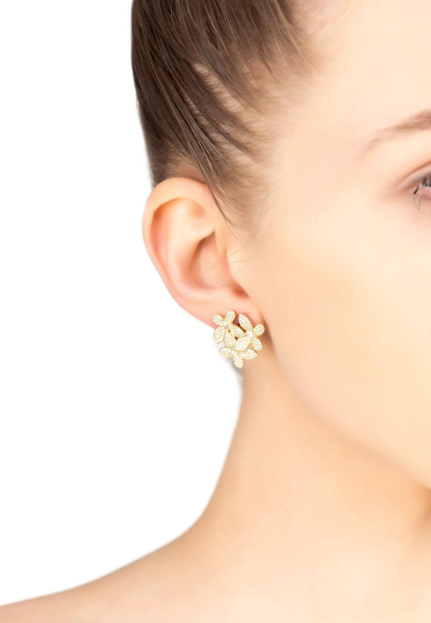 Model wearing gold flower stud earrings with sparkling cubic zirconia blooms, ideal for formal or bridal looks.